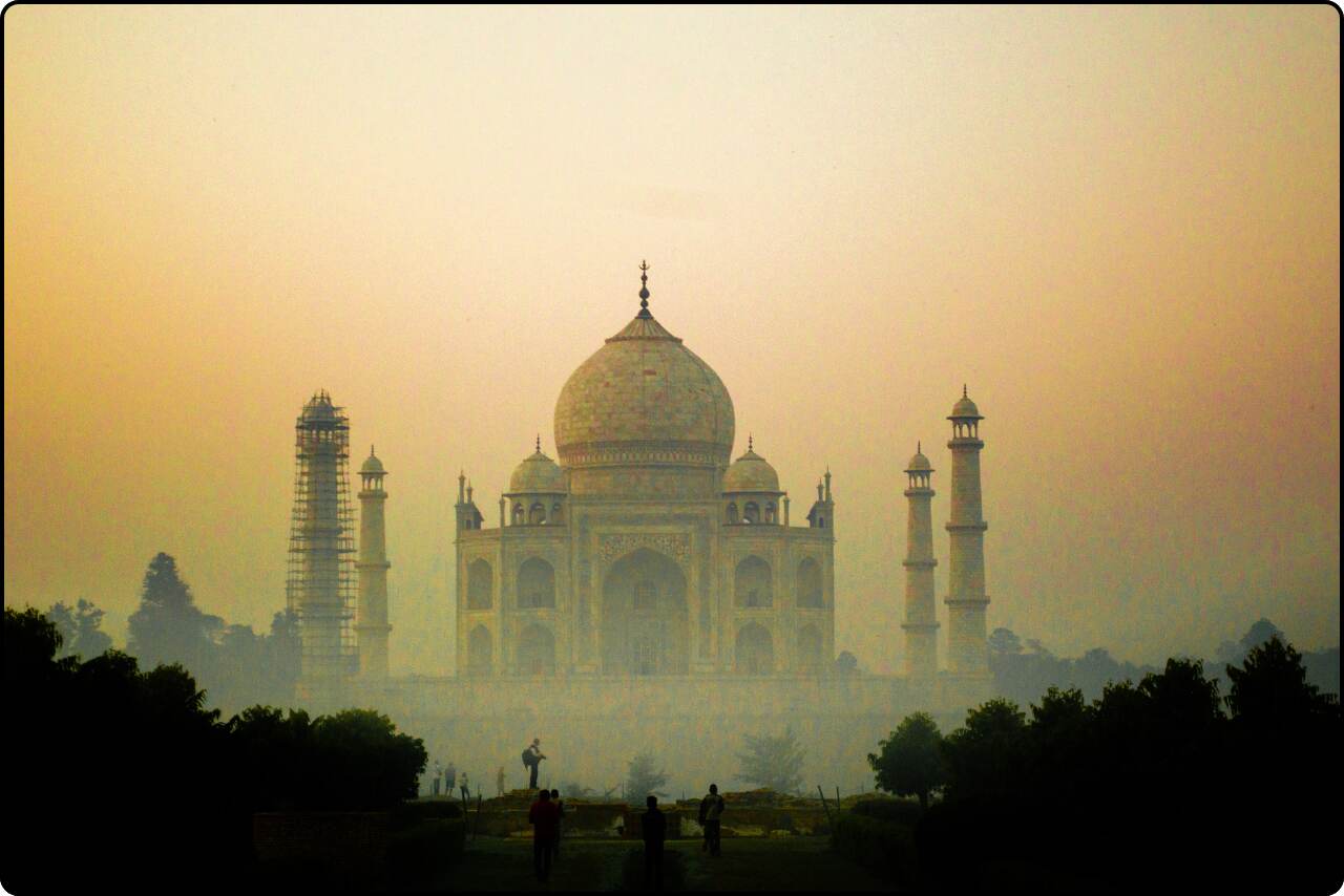 A serene view of the Taj Mahal emerging from the morning mist